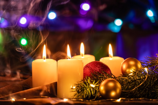 Ein Adventsgesteck mit Kerzen, Tannenzweigen und Christbaumkugeln