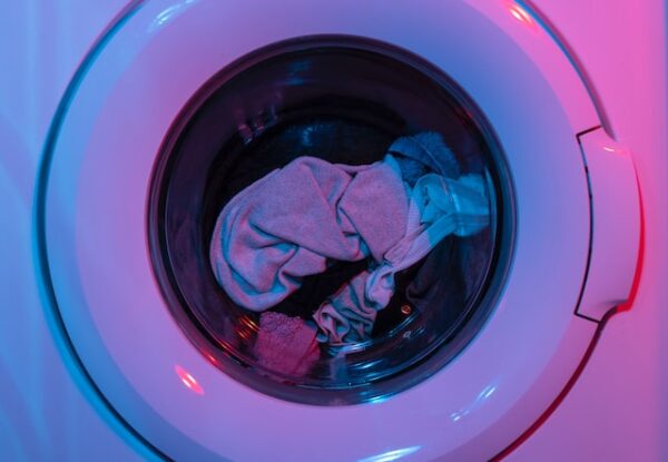 Eine pink-lila beleuchtete Frontlader-Waschmaschine voller Kleidung
