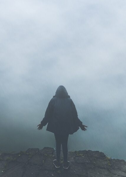 Eine Person steht mit dem Rücken zur Kamera in dichtem Nebel