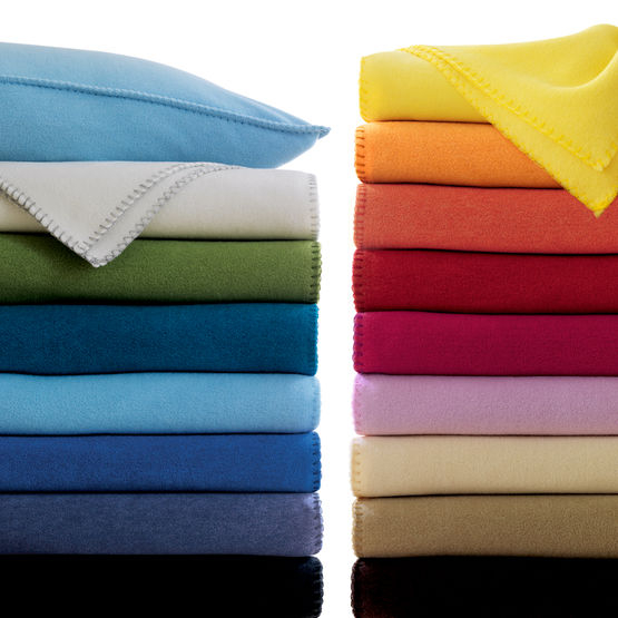 Zwei Stapel gefalteter Fleece-Decken in verschiedenen Farben 